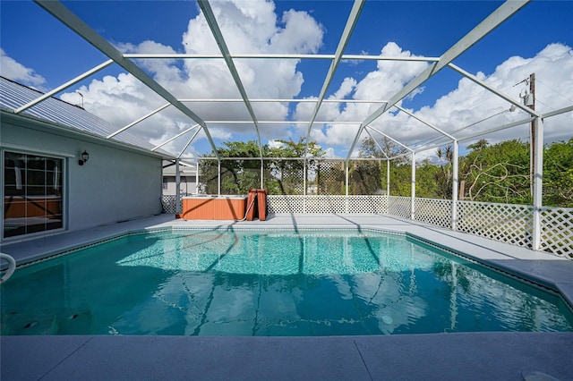 view of swimming pool featuring a lanai and a hot tub