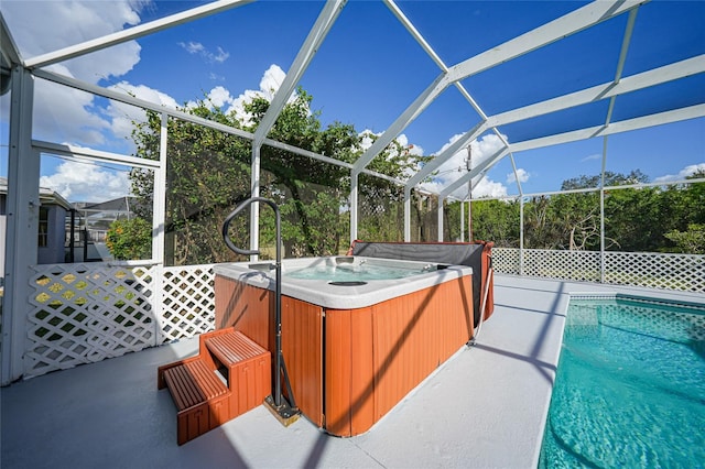 view of swimming pool with a hot tub, a lanai, and a patio area