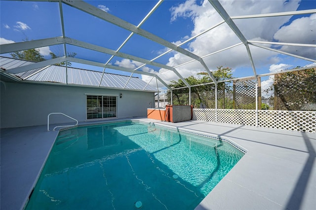 view of swimming pool featuring a lanai and a patio area