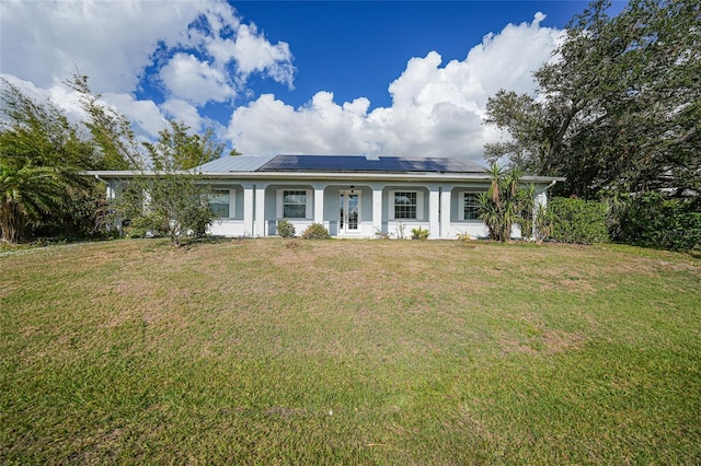 ranch-style home with a front yard, solar panels, and covered porch