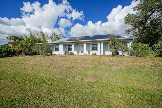 ranch-style house with a porch, a front yard, and solar panels