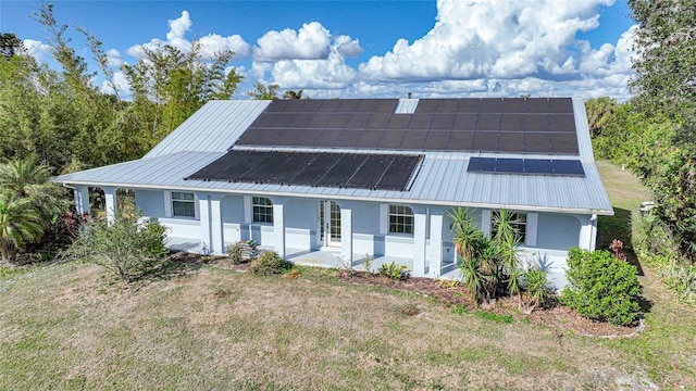 view of front of house with a front yard, covered porch, and solar panels