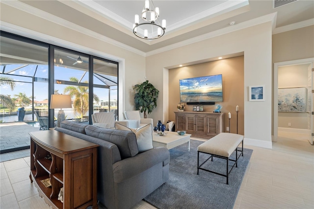 living room with light tile patterned floors, crown molding, a tray ceiling, and an inviting chandelier