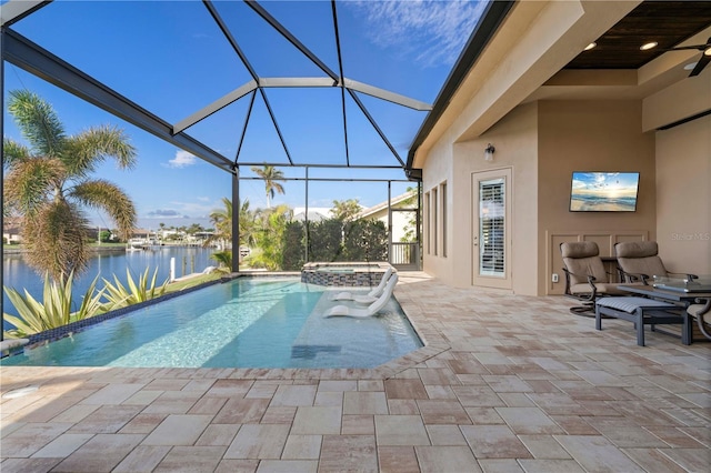 view of pool featuring an in ground hot tub, a water view, glass enclosure, and a patio area