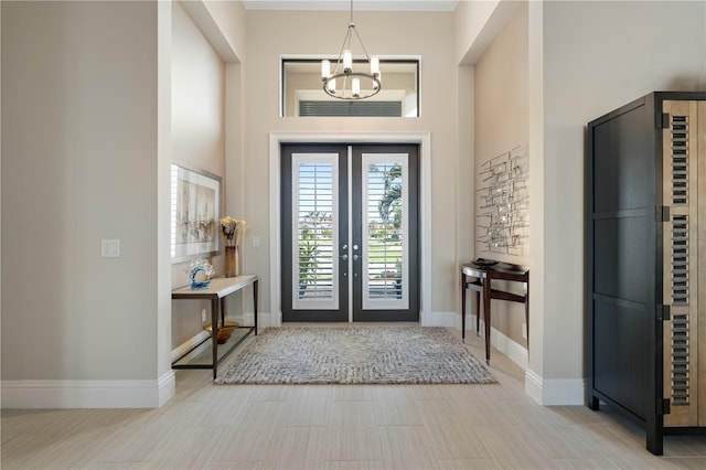 foyer entrance with an inviting chandelier and french doors