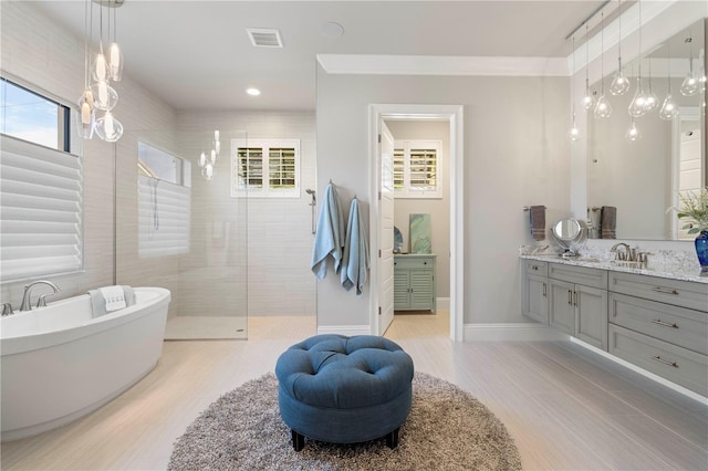 bathroom with vanity, separate shower and tub, a wealth of natural light, and crown molding