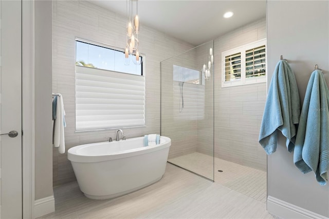 bathroom featuring tile patterned floors, tile walls, and shower with separate bathtub