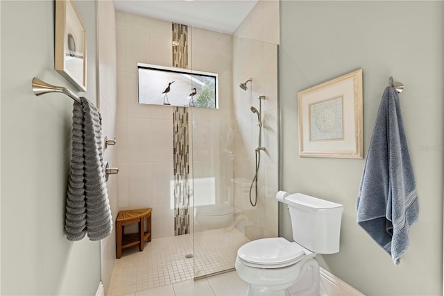 bathroom featuring tile patterned floors, a shower with door, and toilet