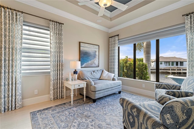 living area featuring hardwood / wood-style flooring, a raised ceiling, ceiling fan, and crown molding