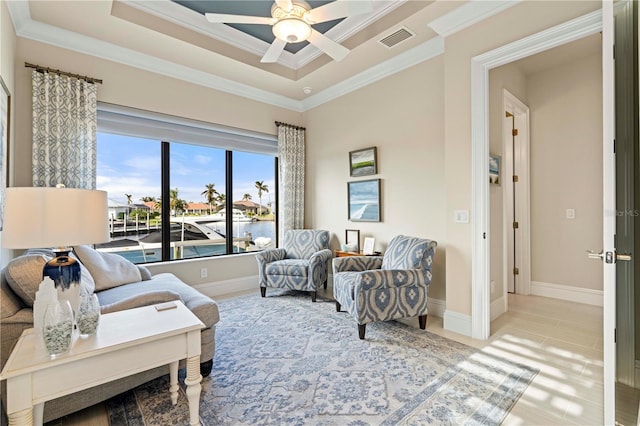 sitting room featuring ceiling fan, a water view, and crown molding