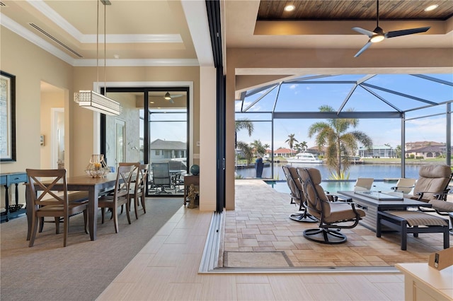 view of patio / terrace with a water view, glass enclosure, and ceiling fan