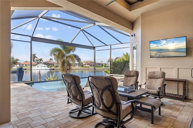 view of patio featuring a water view and a lanai