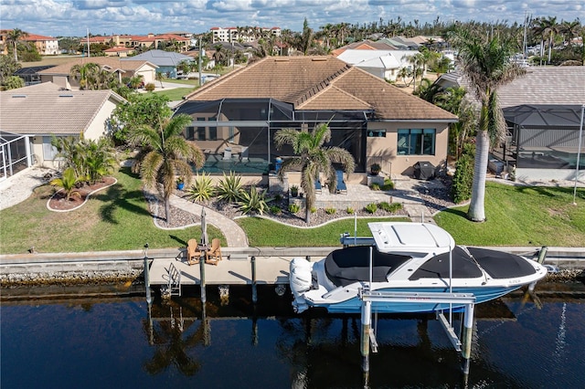 exterior space featuring a lanai, a lawn, and a water view