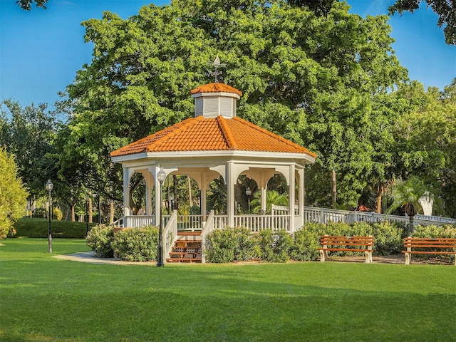 view of community with fence, a lawn, and a gazebo