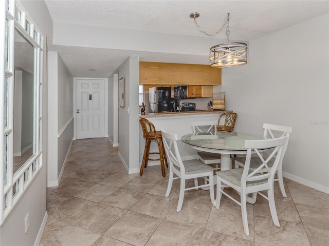 dining space featuring a textured ceiling and baseboards