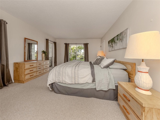 bedroom with light colored carpet and a textured ceiling