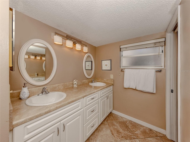 bathroom featuring vanity, tile patterned flooring, and a textured ceiling