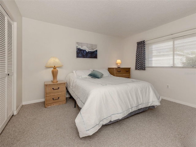 bedroom featuring light carpet, a closet, and a textured ceiling