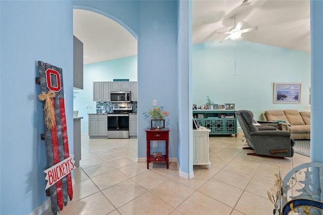 interior space with light tile patterned floors, ceiling fan, and lofted ceiling