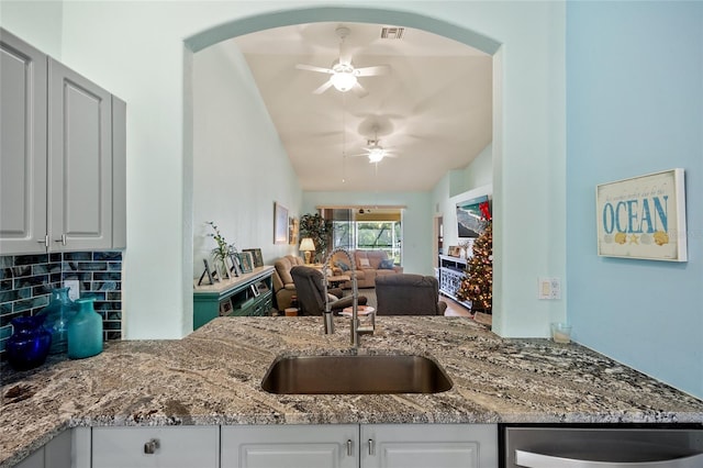 kitchen featuring tasteful backsplash, white cabinetry, ceiling fan, and sink