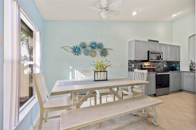 tiled dining area featuring vaulted ceiling and ceiling fan