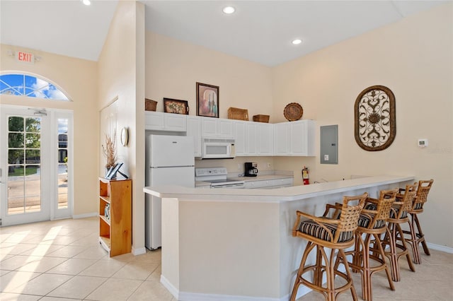 kitchen featuring kitchen peninsula, white appliances, electric panel, and white cabinetry