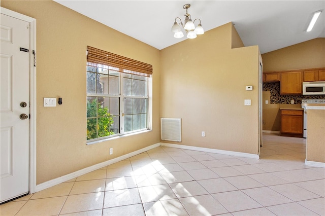 unfurnished dining area featuring light tile patterned flooring, lofted ceiling, and a notable chandelier