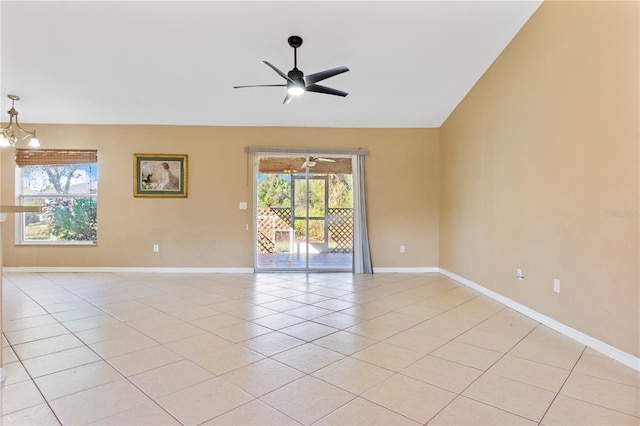 tiled spare room with ceiling fan with notable chandelier and vaulted ceiling