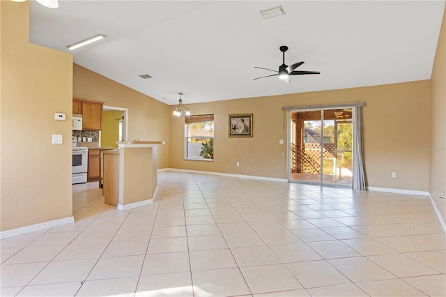 tiled spare room featuring ceiling fan with notable chandelier and lofted ceiling