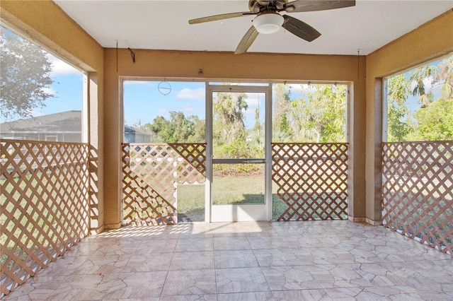 unfurnished sunroom with ceiling fan