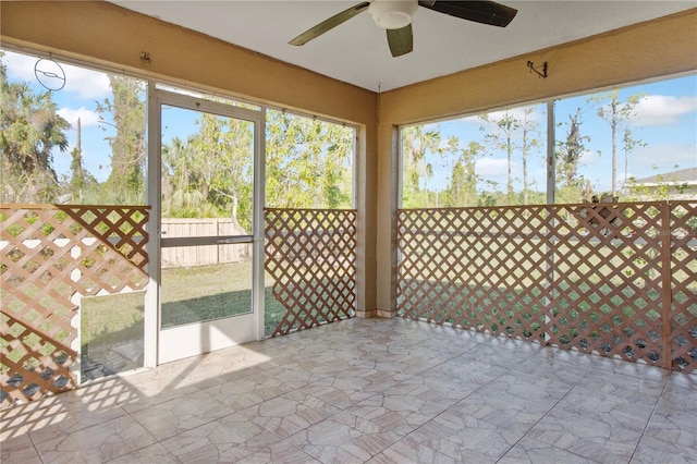 unfurnished sunroom featuring ceiling fan