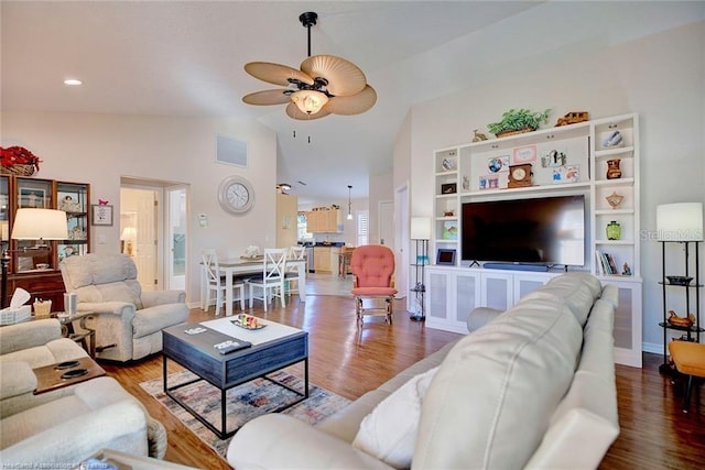 living room with ceiling fan, wood-type flooring, and vaulted ceiling