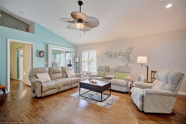 living room with ceiling fan, light hardwood / wood-style floors, and lofted ceiling