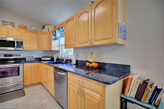 kitchen with light brown cabinets, dark stone countertops, sink, and appliances with stainless steel finishes