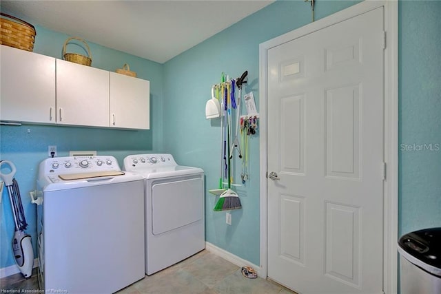 washroom featuring cabinets, light tile patterned flooring, and washing machine and clothes dryer