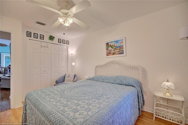 bedroom with ceiling fan, a closet, and wood-type flooring