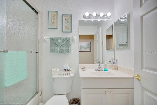 full bathroom featuring vanity, bath / shower combo with glass door, and toilet