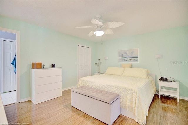 bedroom with a closet, ceiling fan, and light hardwood / wood-style flooring