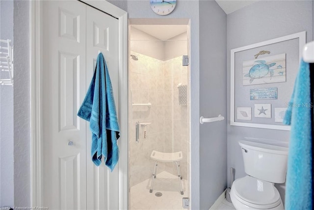 bathroom featuring toilet and a shower with door