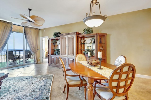 dining area featuring light tile patterned floors, a water view, and ceiling fan