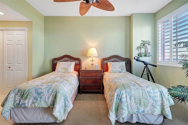 carpeted bedroom with ceiling fan and a closet