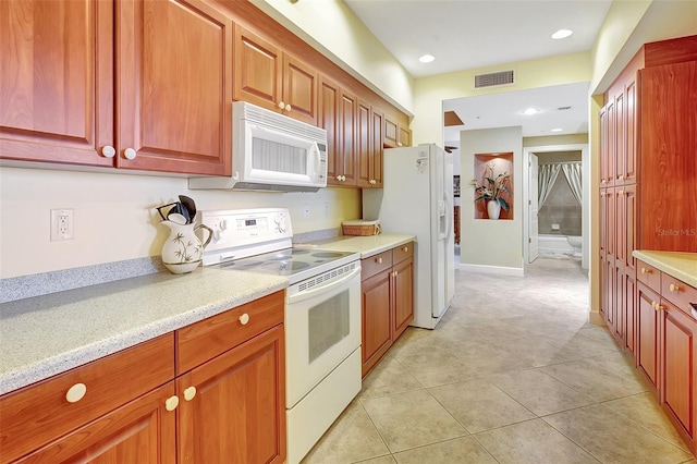 kitchen with white appliances and light tile patterned flooring