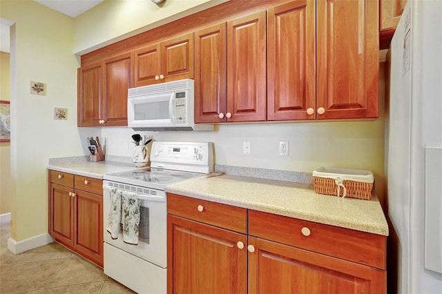 kitchen featuring light tile patterned flooring and white appliances