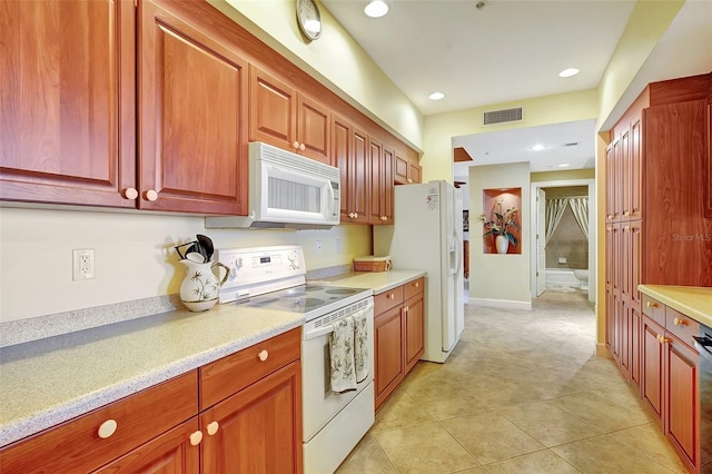 kitchen featuring light tile patterned floors and white appliances