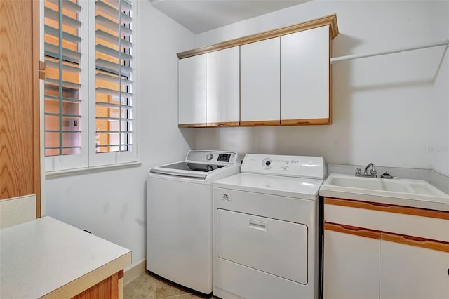 washroom with light tile patterned flooring, cabinets, sink, and washing machine and dryer