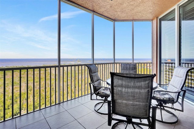 sunroom / solarium featuring a water view and a wealth of natural light