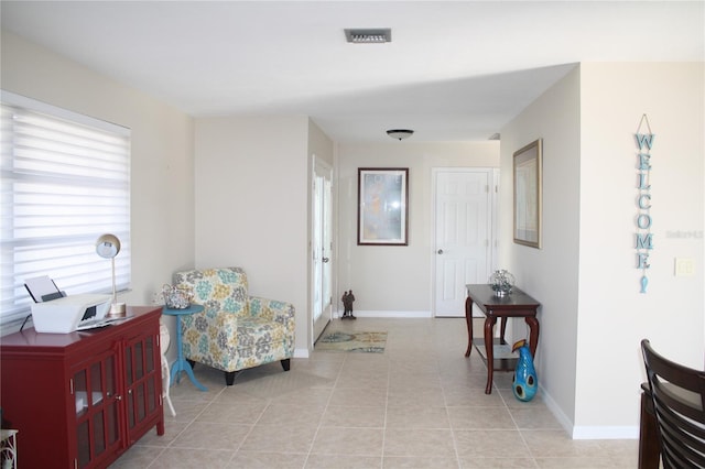 hallway featuring a wealth of natural light and light tile patterned flooring