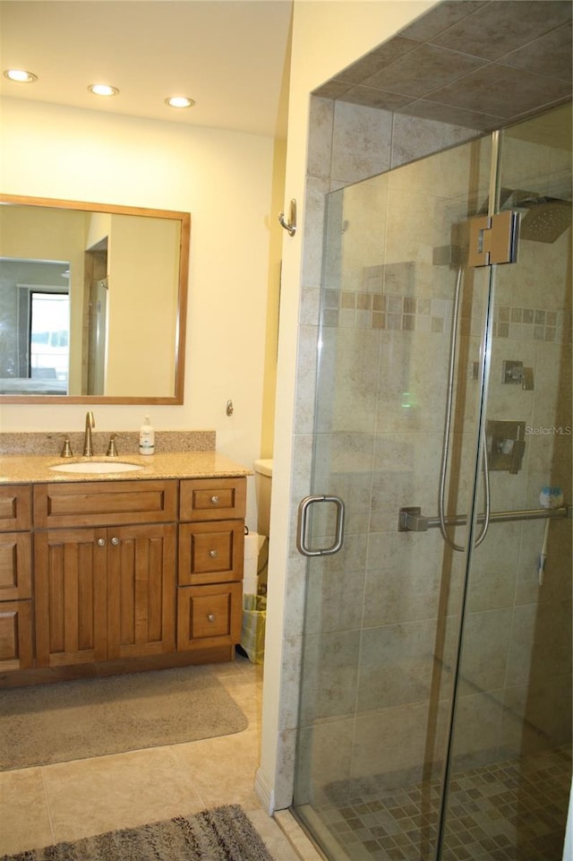 bathroom with tile patterned flooring, vanity, and a shower with door