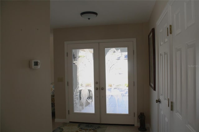 doorway to outside with light tile patterned floors and french doors