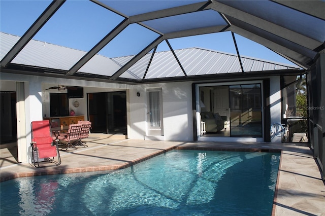 rear view of property with exterior bar, glass enclosure, ceiling fan, and a patio area